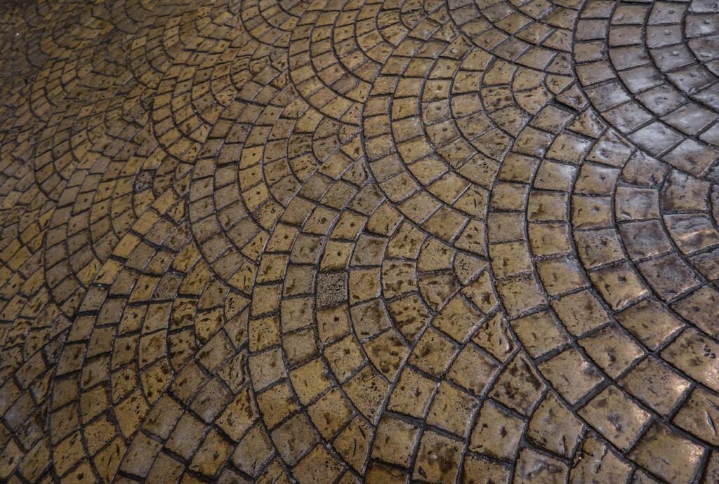 Close-up of a detailed cobblestone floor with an intricate circular pattern, perfect for backgrounds or design inspiration.